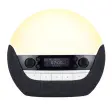 Lumie Bodyclock Luxe DAB, en stor kupolformad väckningslampa med mörk textilsockel, knappar och display, fotad mot vit bakgrund