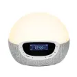 Lumie Bodyclock Shine, en kupolformad väckningslampa med grå textilsockel och display med FM-frekvens, fotad mot vit bakgrund