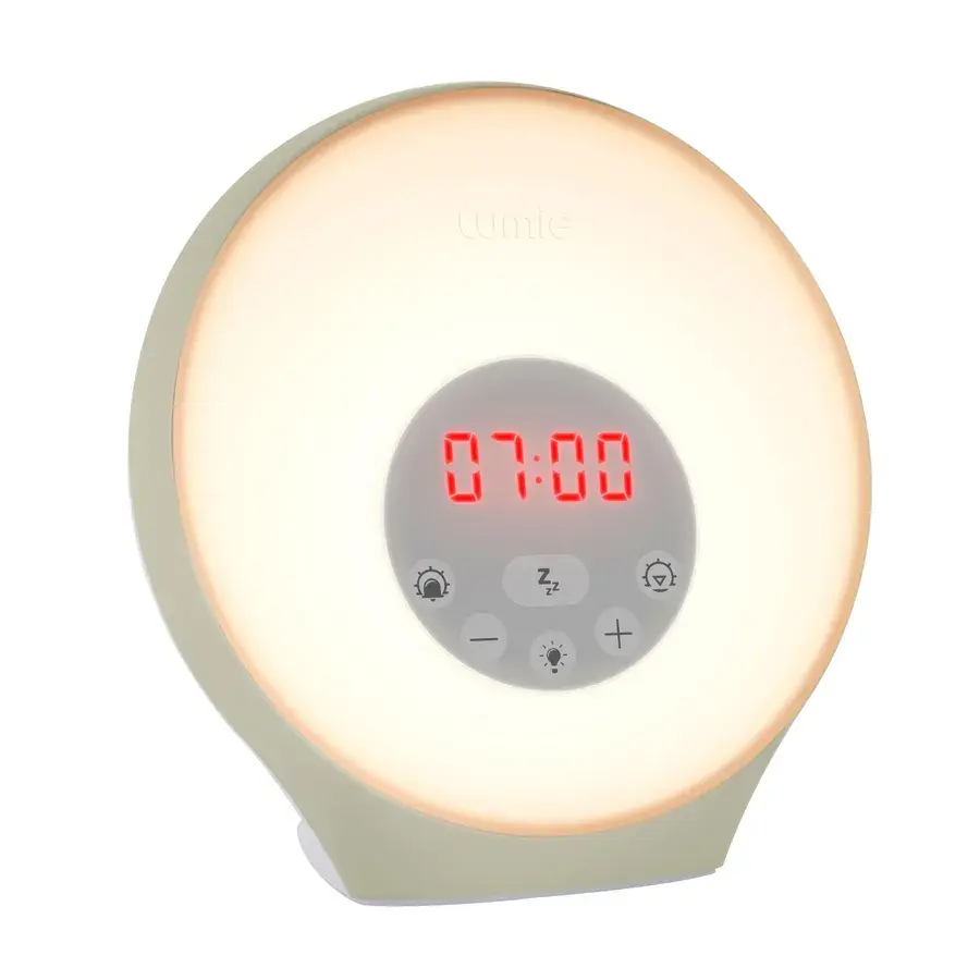 Lumie Sunrise Alarm, en rund väckningslampa i ljust grågrönt med röd digital klocka på 07:00, fotad mot vit bakgrund